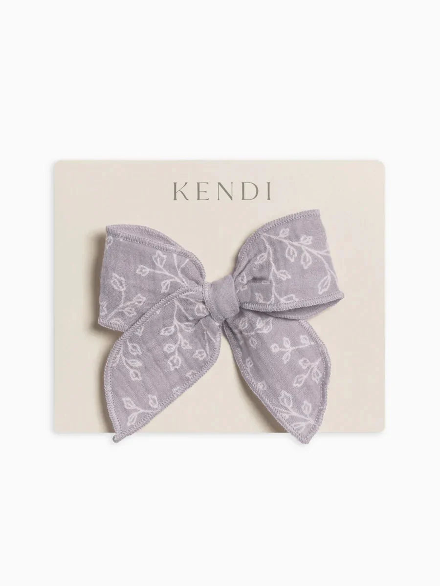 Muslin bow clip with floral pattern on an alligator clip, made from 100% organic cotton.