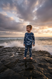 2-Year-Old Boy in Blue Whale Pajama Set on Coastal Scene