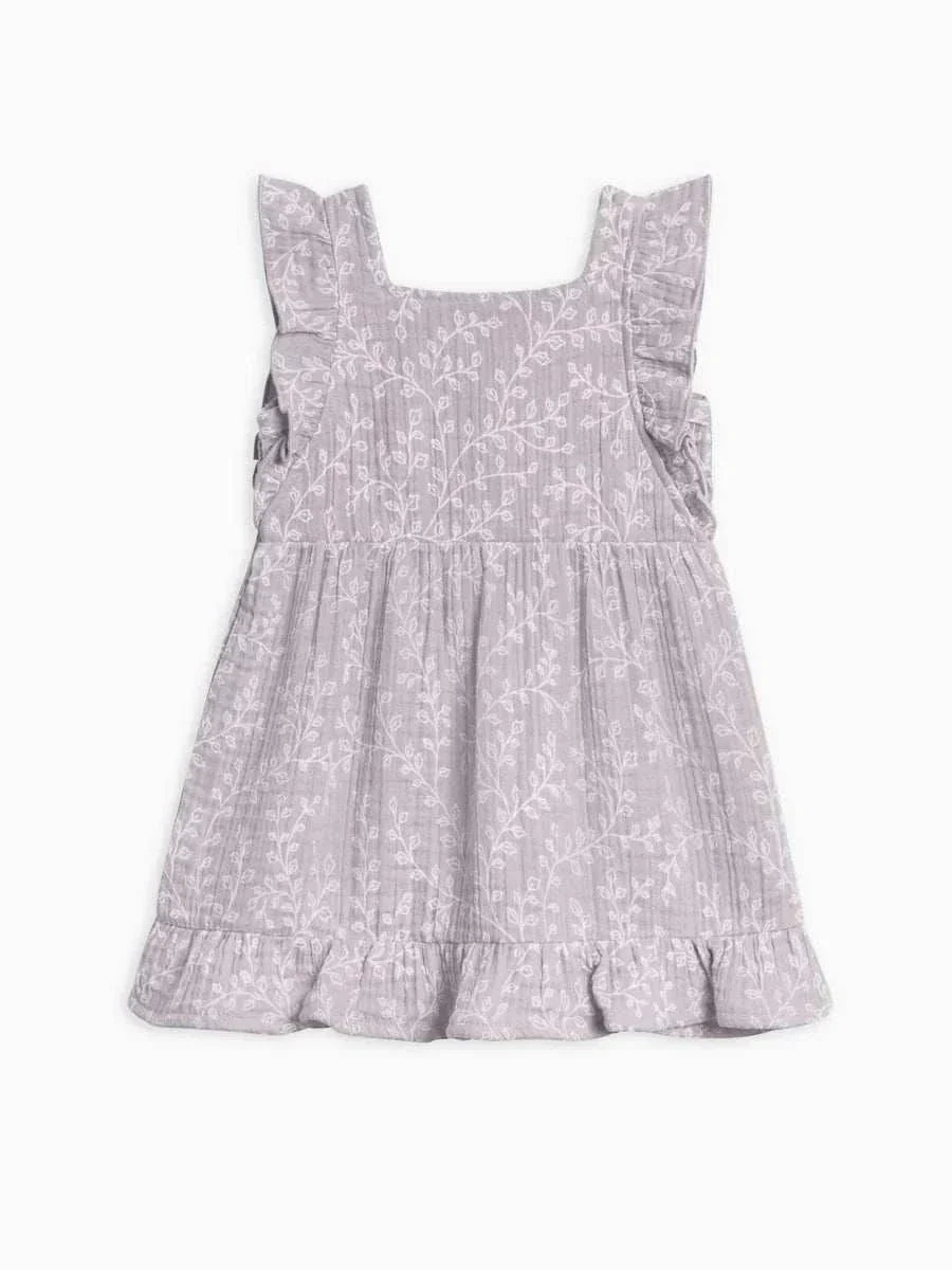 Jane Muslin Dress with ruffle hem and square neckline, featuring delicate wooden buttons and floral design.