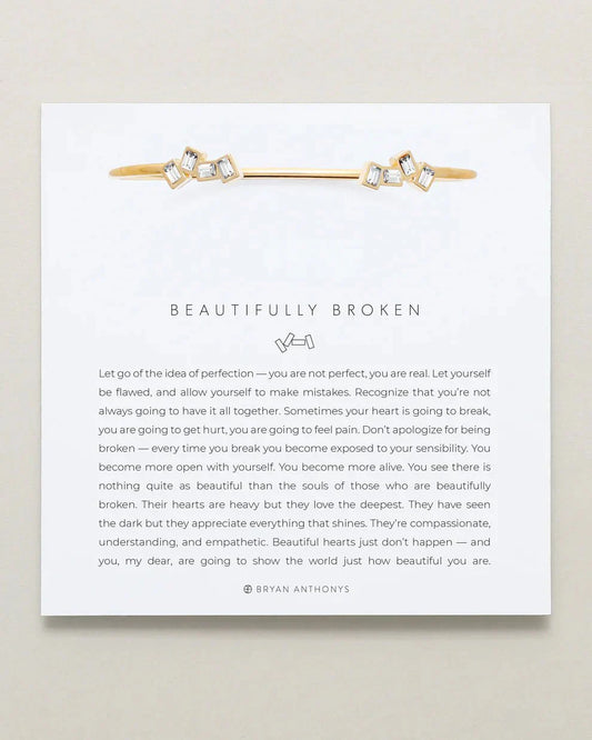 Adjustable "Beautifully Broken Cuff" in brass with 14k gold finish, emphasizes imperfection and resilience.