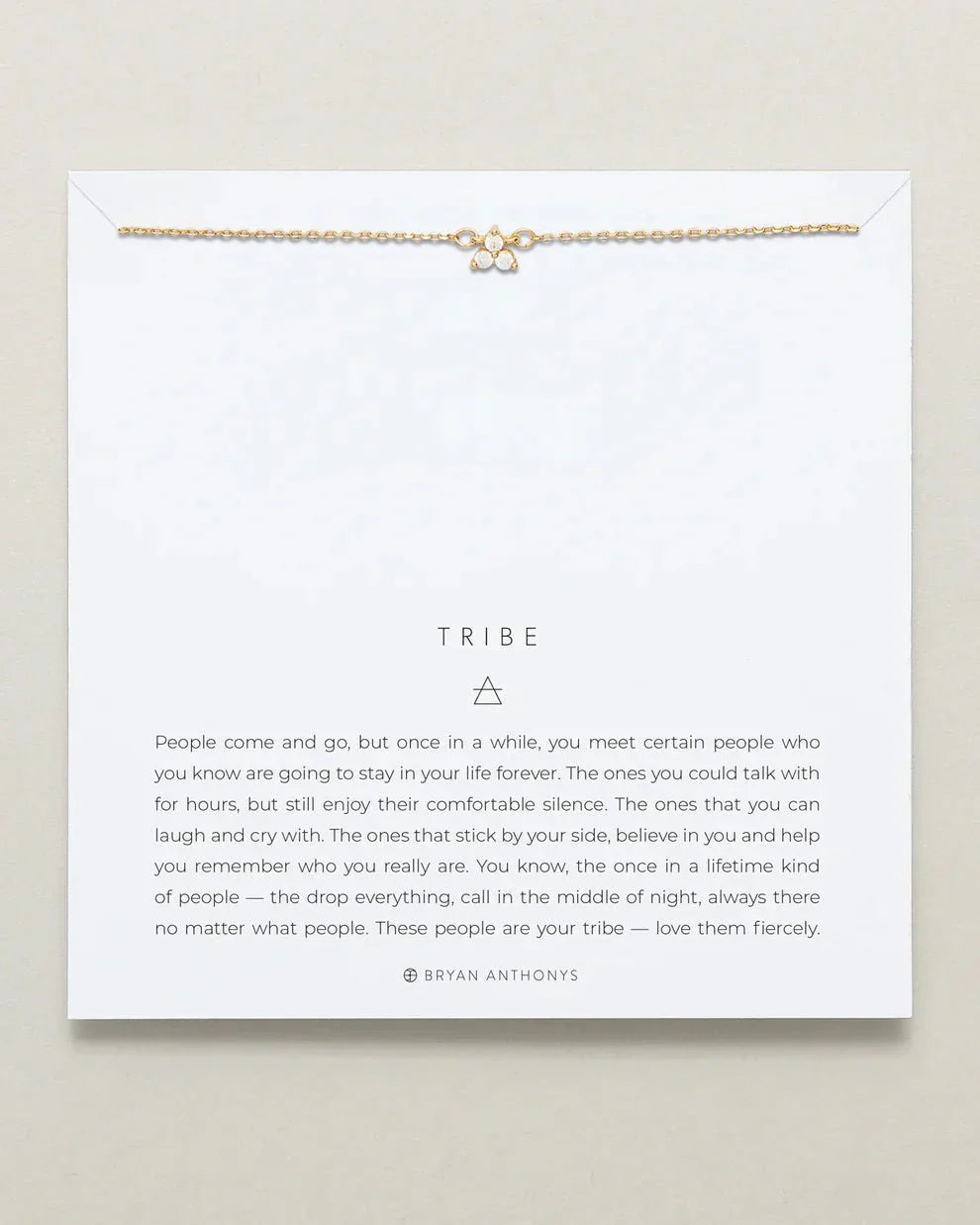 TRIBE DAINTY friendship necklace on display card, featuring an adjustable brass chain with a small pendant, available in 14k gold and silver finishes.