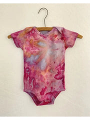 Organic Wildflower Onesies hand-dyed in vibrant colors on a hanger, featuring soft organic cotton fabric.