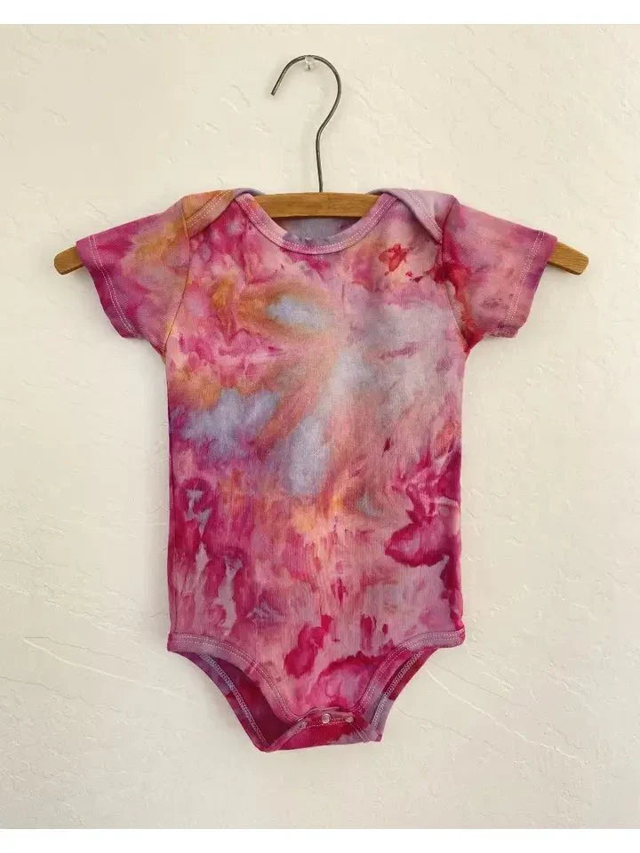 Organic Wildflower Onesies hand-dyed in vibrant colors on a hanger, featuring soft organic cotton fabric.