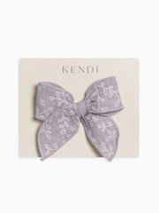 Muslin bow clip with floral pattern on an alligator clip, made from 100% organic cotton.
