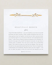 Adjustable "Beautifully Broken Cuff" in brass with 14k gold finish, emphasizes imperfection and resilience.