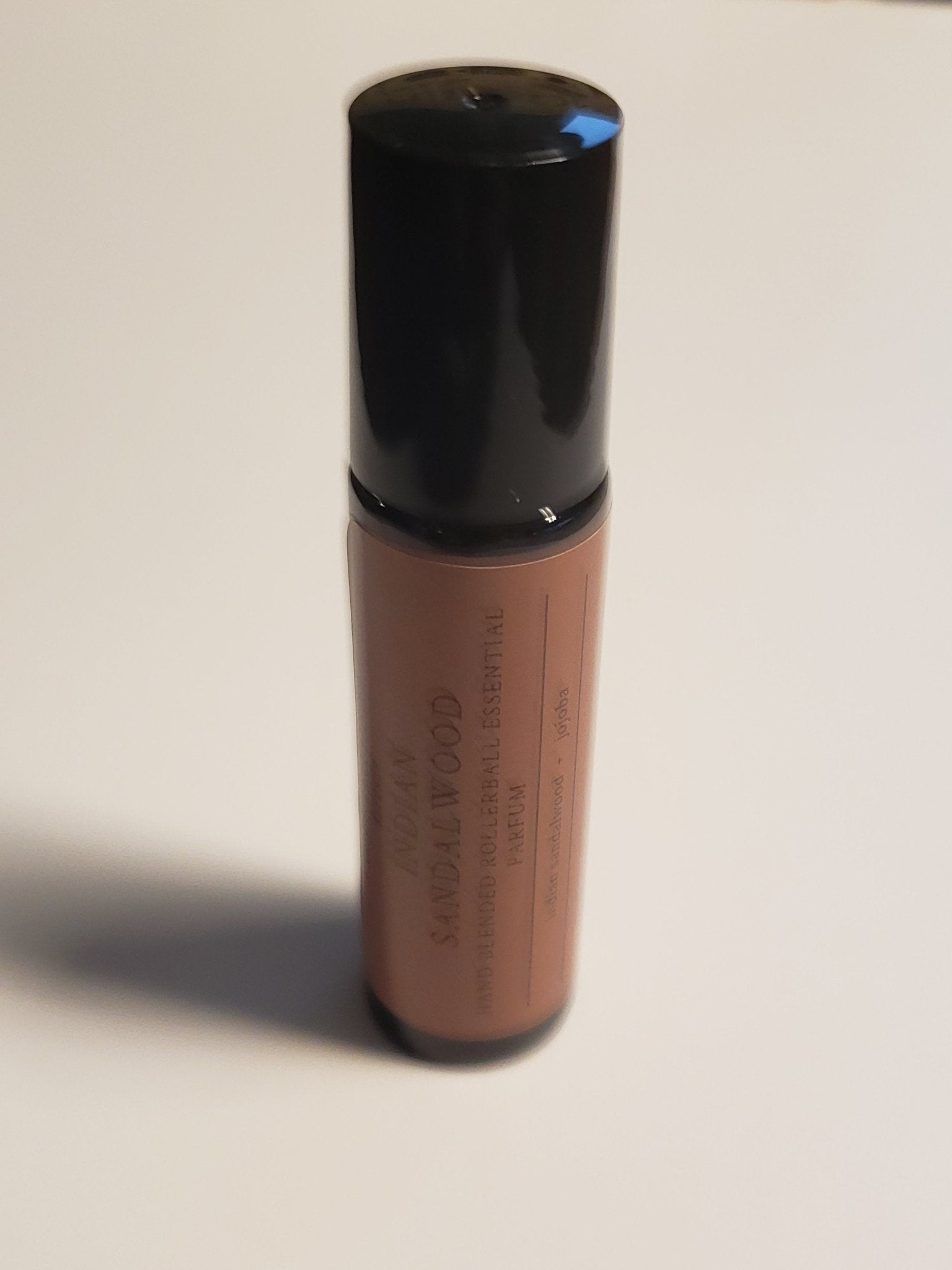 Indian Sandalwood Roll-On bottle with black cap, featuring a luxurious blend of organic Jojoba Seed Oil and Indian Sandalwood Essential Oil.